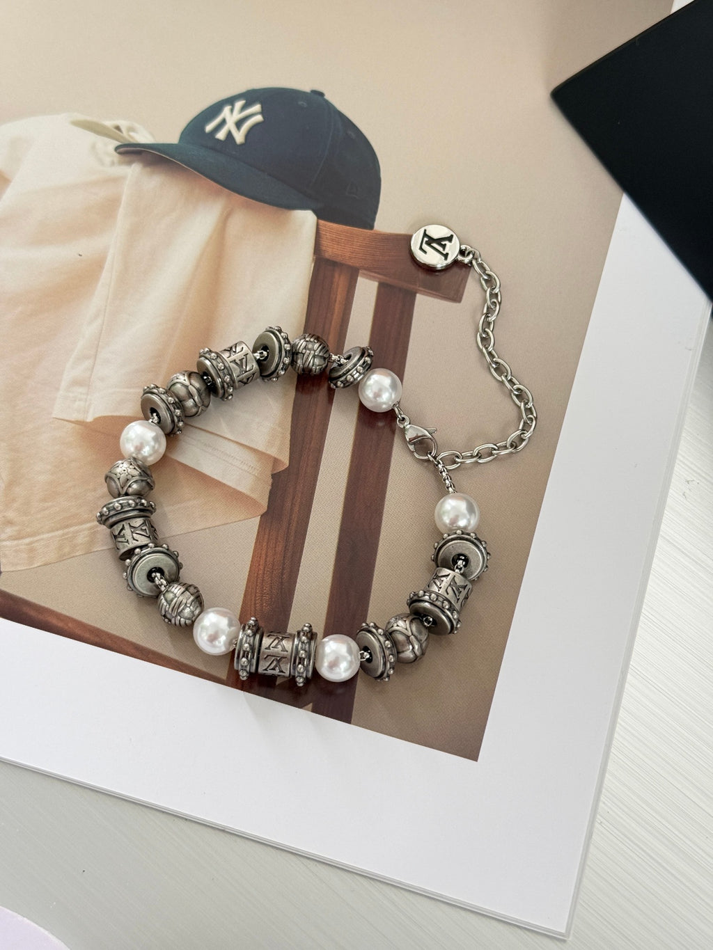 Silver-tone beaded charm bracelet with pearl beads and chain loop, LV logo center