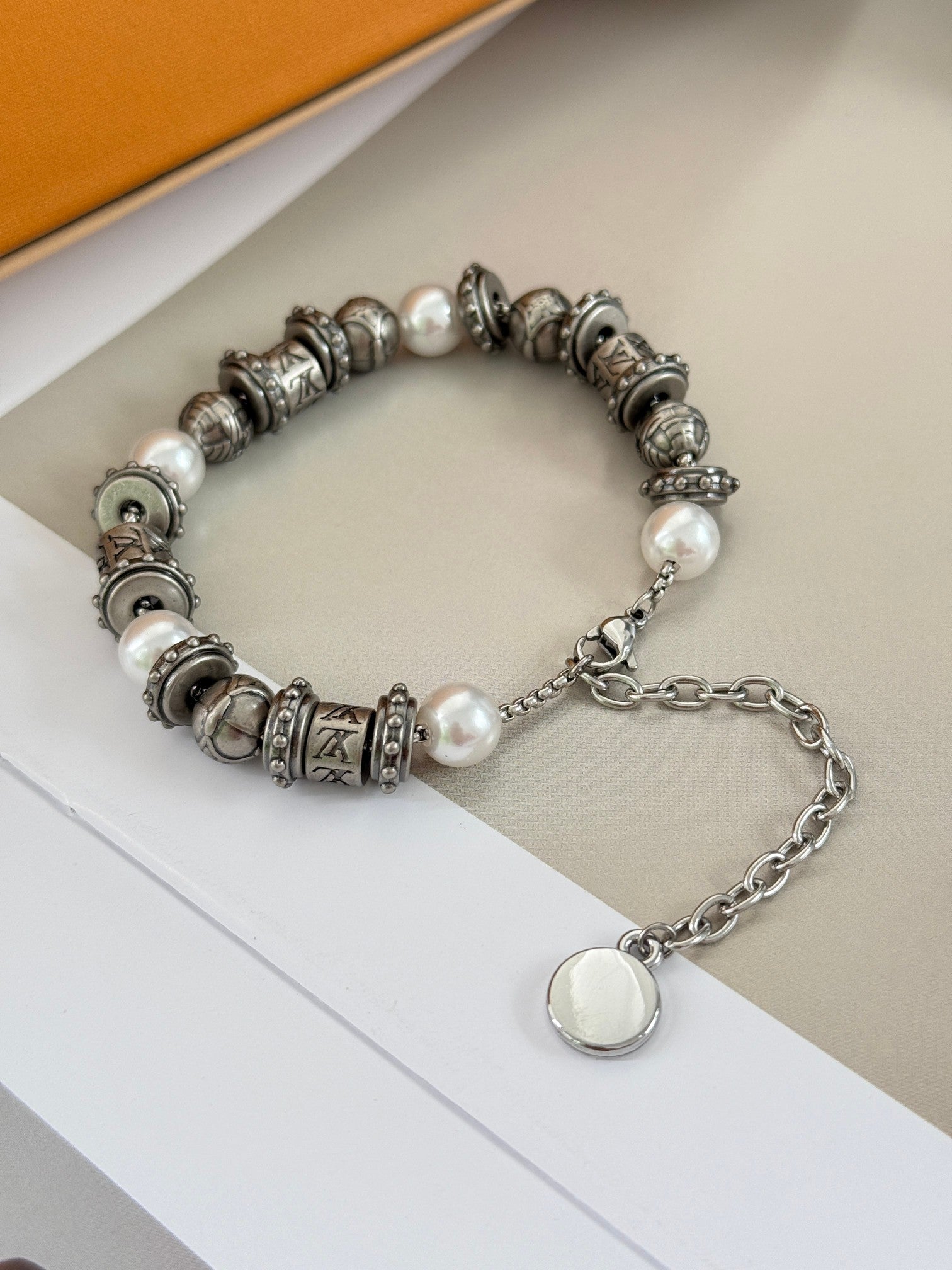 Silver-tone beaded bracelet with pearl accents and chain extender, LV logo charm