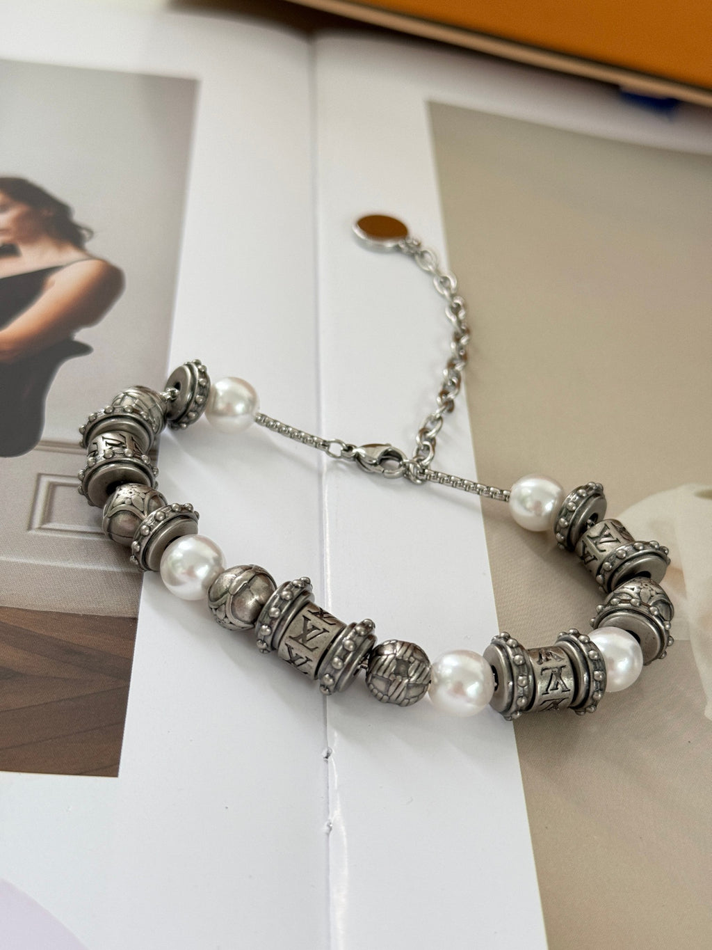 Silver-tone beaded charm bracelet with pearl beads and LV logo charms, chain extender