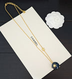 Gold-tone double chain necklace with Chanel text and blue round crystal pendant