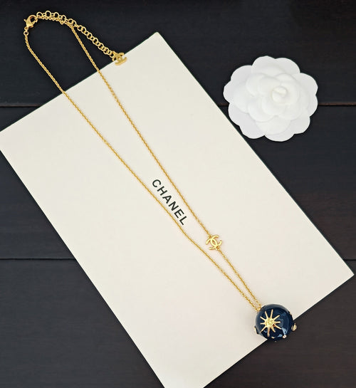 Gold-tone double chain necklace with Chanel text and blue round crystal pendant
