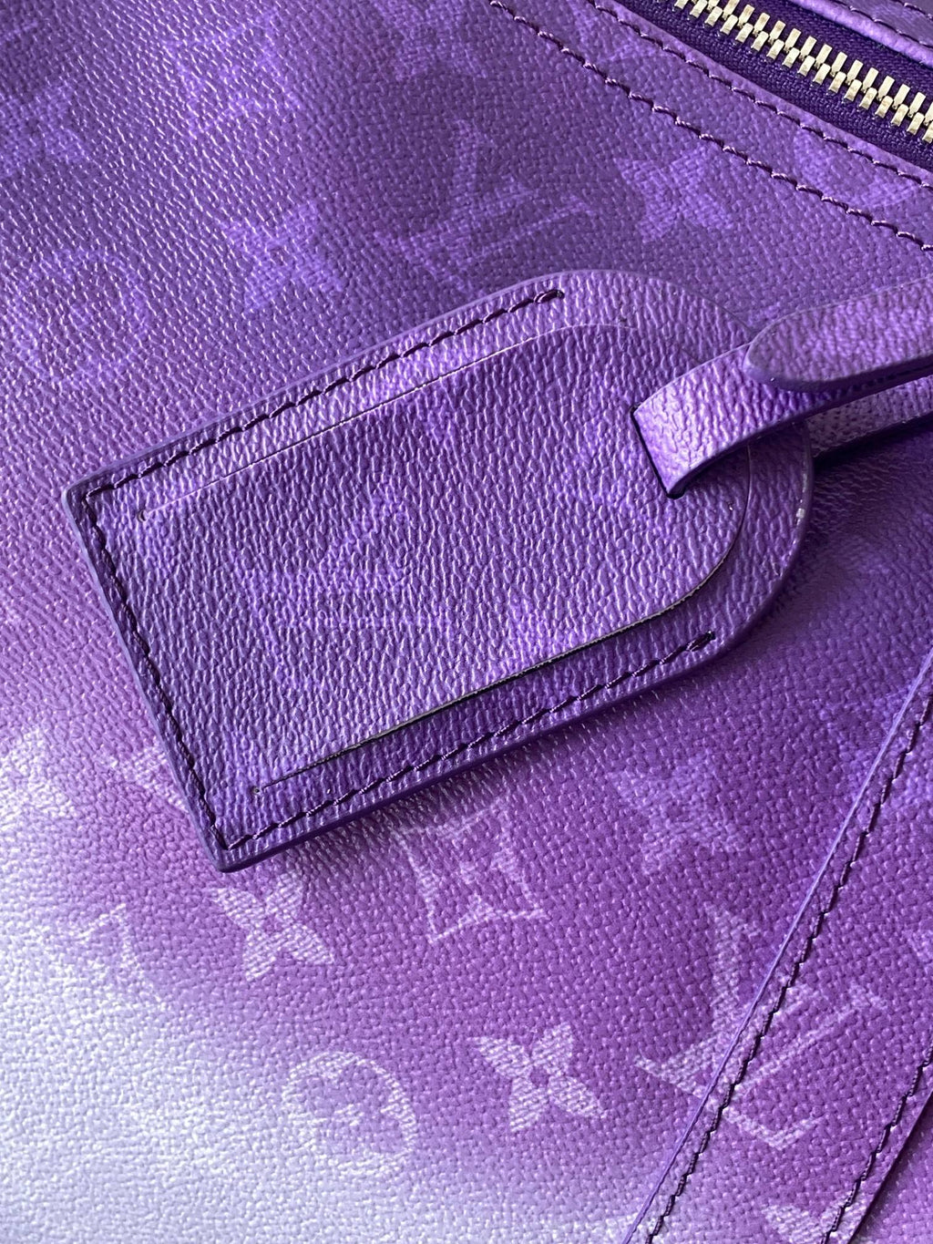 Purple textured leather panel with embossed monogram and stitched leather edge