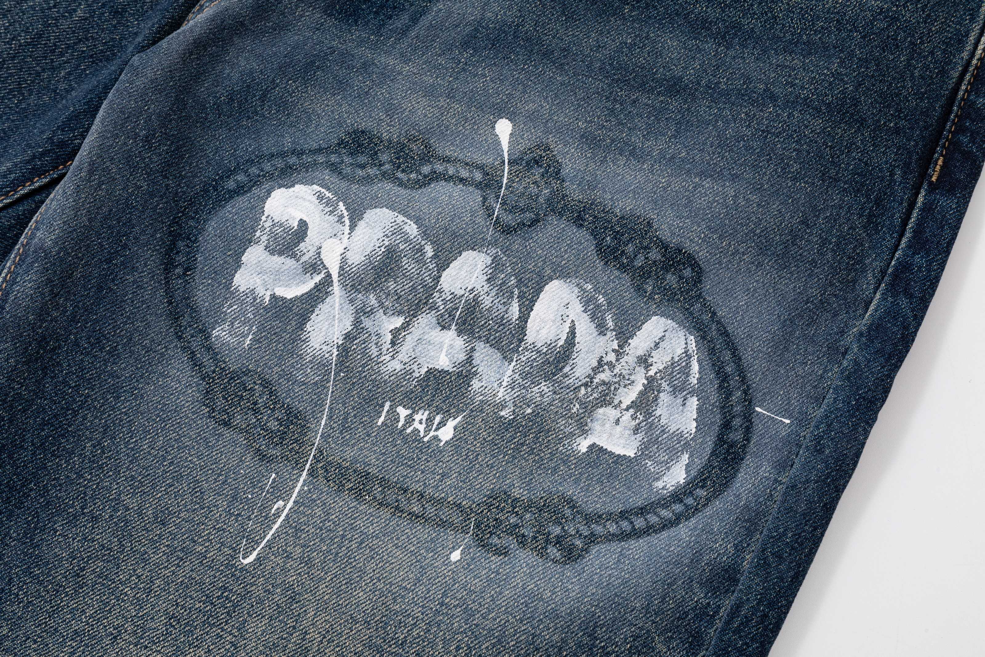 Prada denim pants leg close-up with oval graphic print and decorative lines