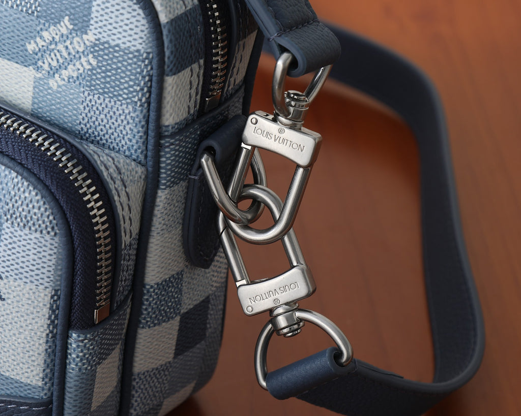 Louis Vuitton crossbody strap attachment with silver-tone rings and clasp hardware