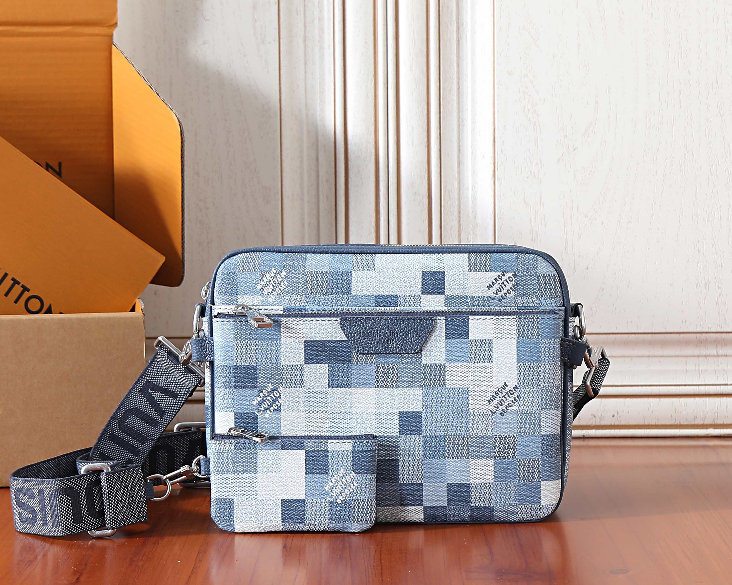 Louis Vuitton crossbody bag in blue and white checkered canvas, top zipper.