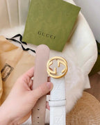 Gucci belt with white embossed strap, light pink backing, and gold double-G buckle