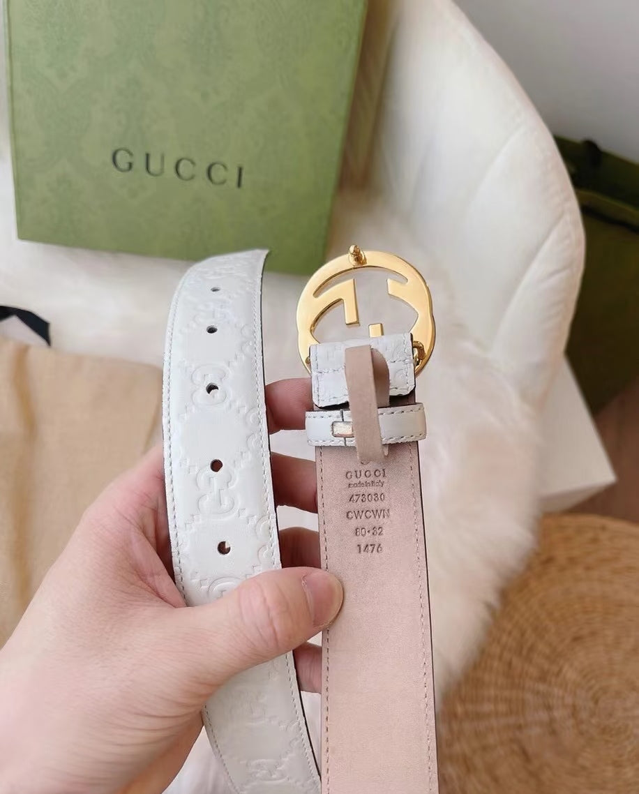 Gucci belt with white and light pink straps, gold buckle, and hanging label