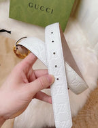 Gucci belt strap close-up in white with embossed logo and gold buckle hardware