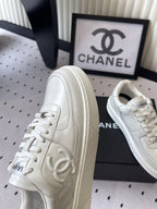 White leather sneaker, front side view with Chanel CC emblem on panel