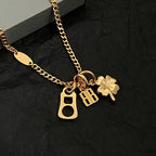 Gold charm necklace with BB, key, and clover pendants on the chain