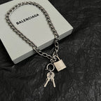 Silver-tone chain bracelet with padlock charm and keys, shown with a box