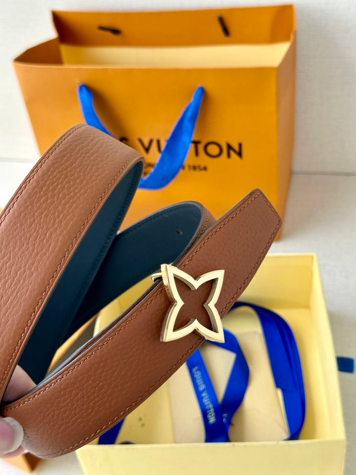 Tan belt and navy-edged strap with silver star buckle detail, shown in box