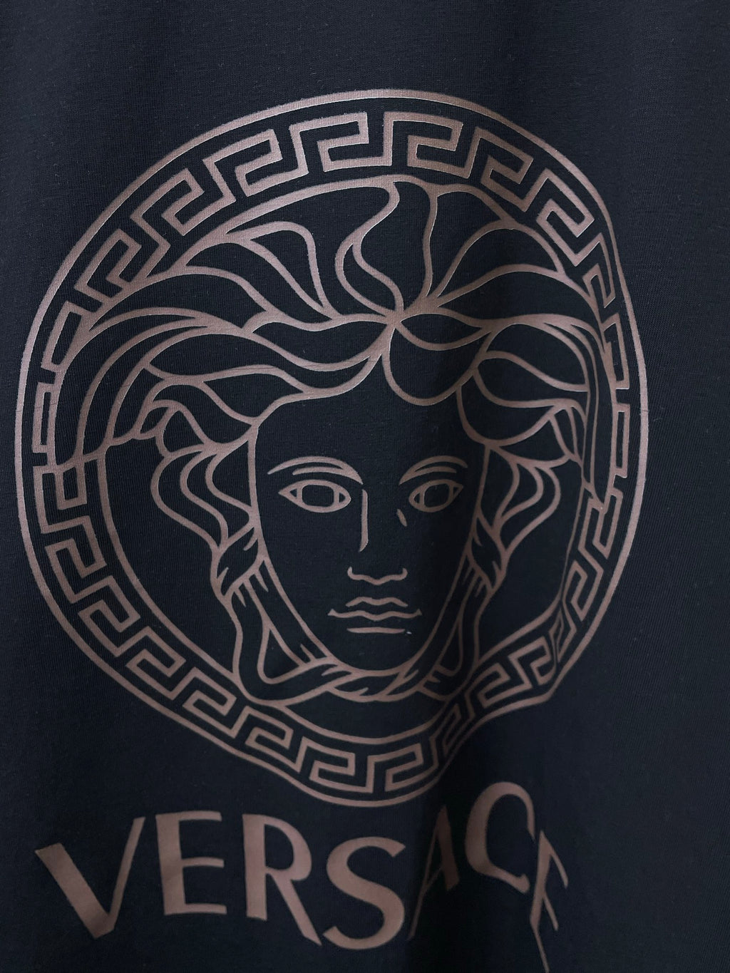 Versace black T-shirt close-up of Medusa logo and VERSACE lettering