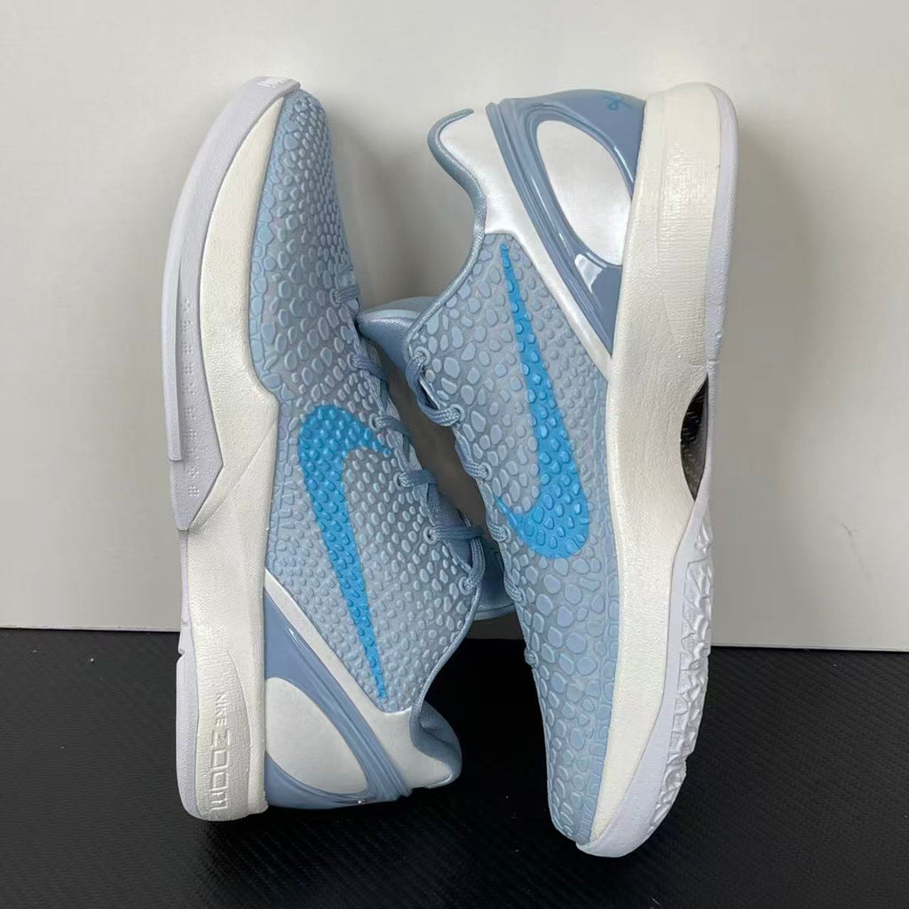 Light blue and gray basketball shoes with white sole, blue swoosh panel, lace-up.