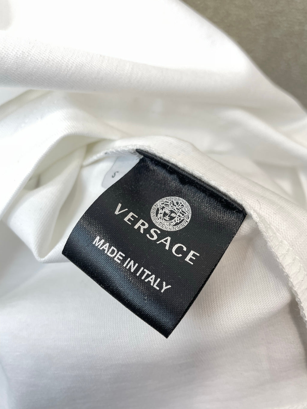 Inside neck label: VERSACE, MADE IN ITALY on white T-shirt.