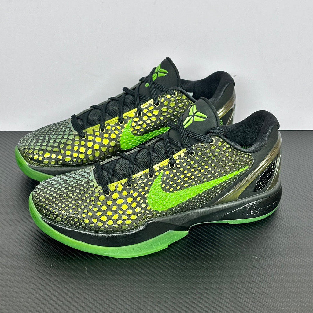 Pair of black and green basketball shoes with neon laces, textured upper, and bright green sole.