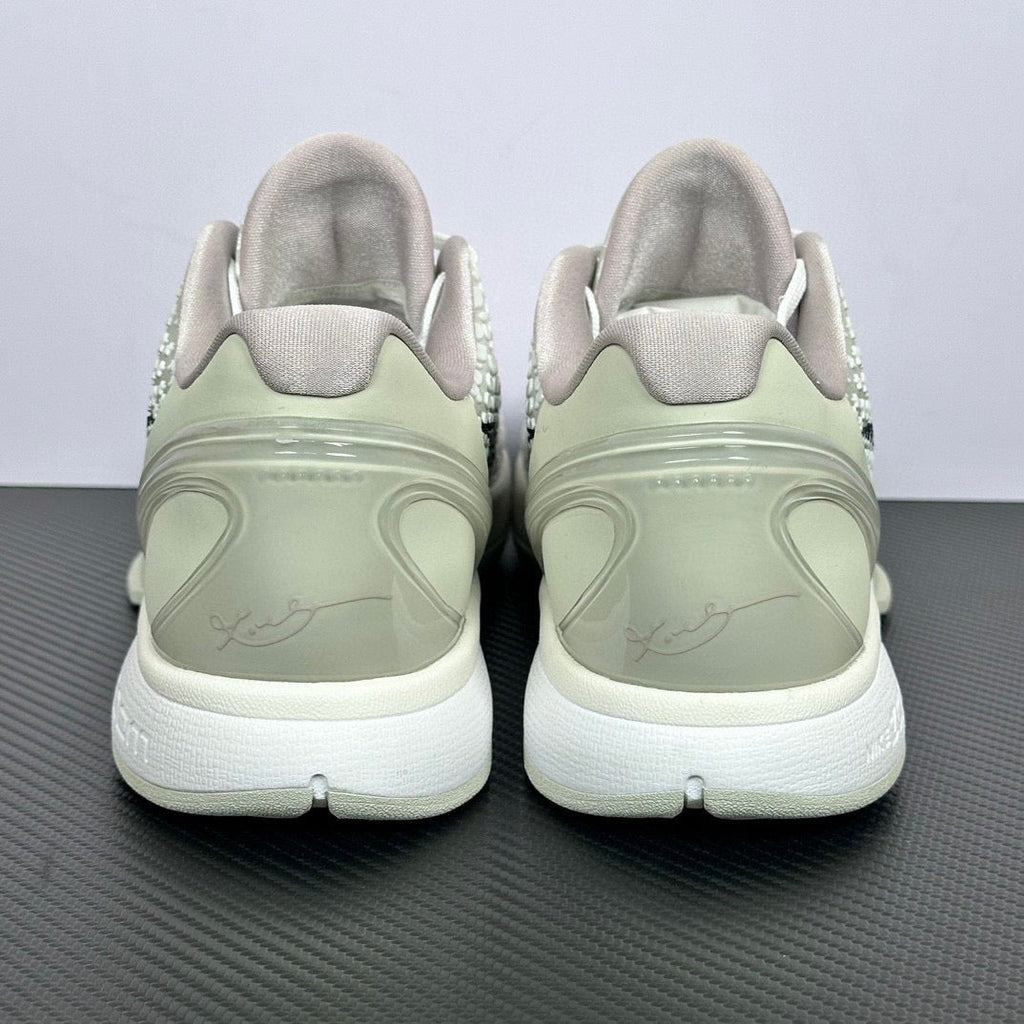 Pair of low-top sneakers back view, pale green heel and collar, white outsole