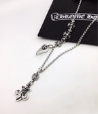 Silver chain necklace with fleur-de-lis links and lock charm, shown near pouch