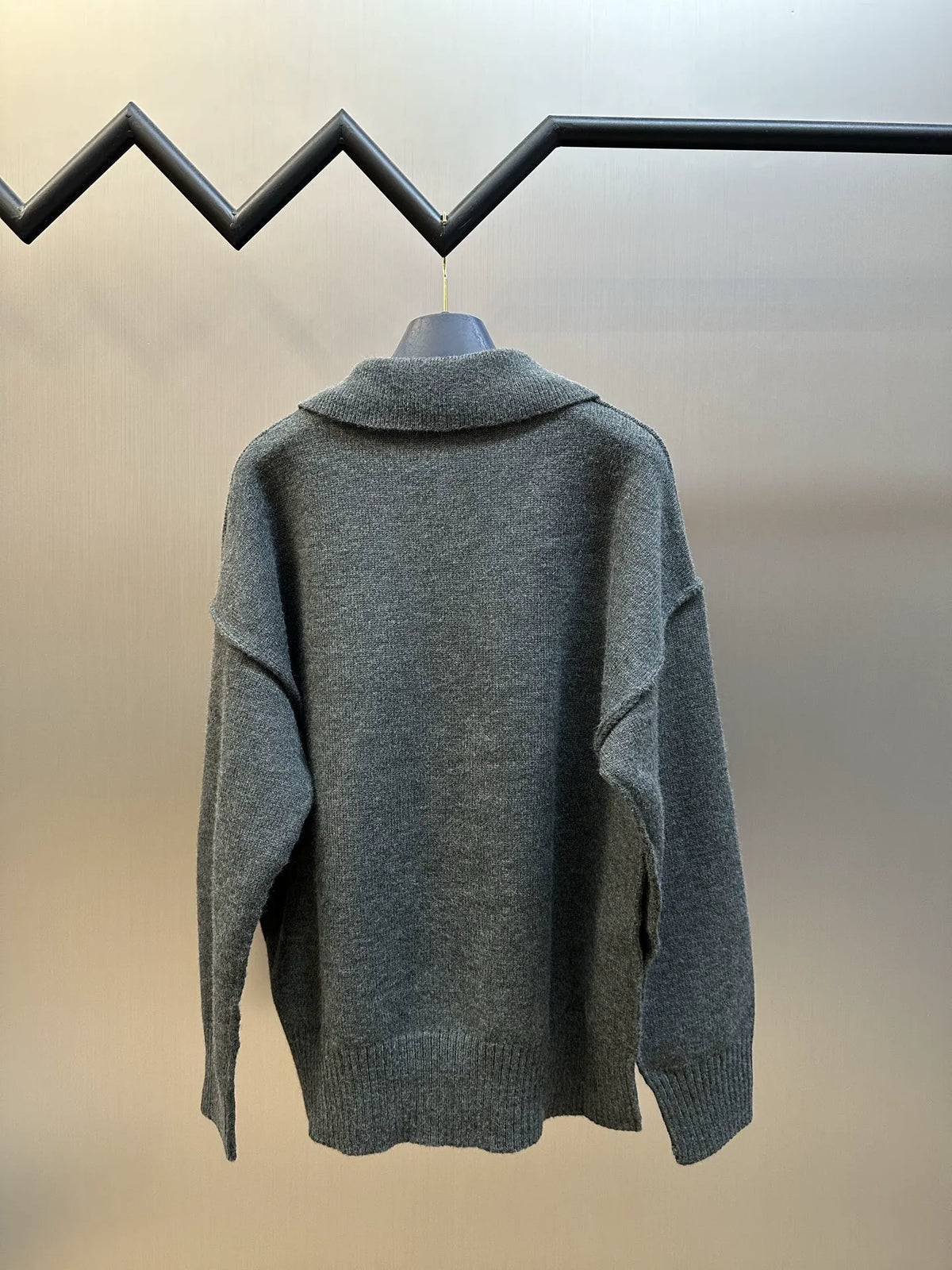 Grey knit polo sweater back view with ribbed high collar and cuffs