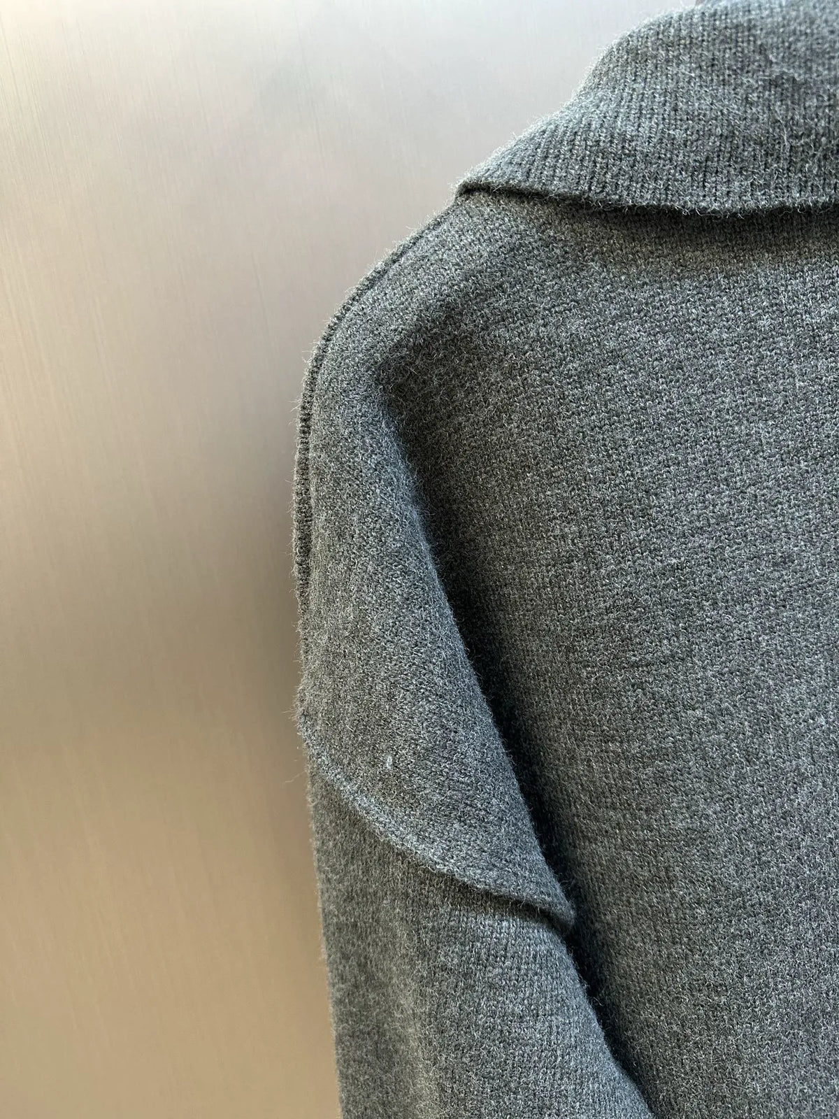 Grey knit polo sweater with ribbed collar and sleeve seam detail