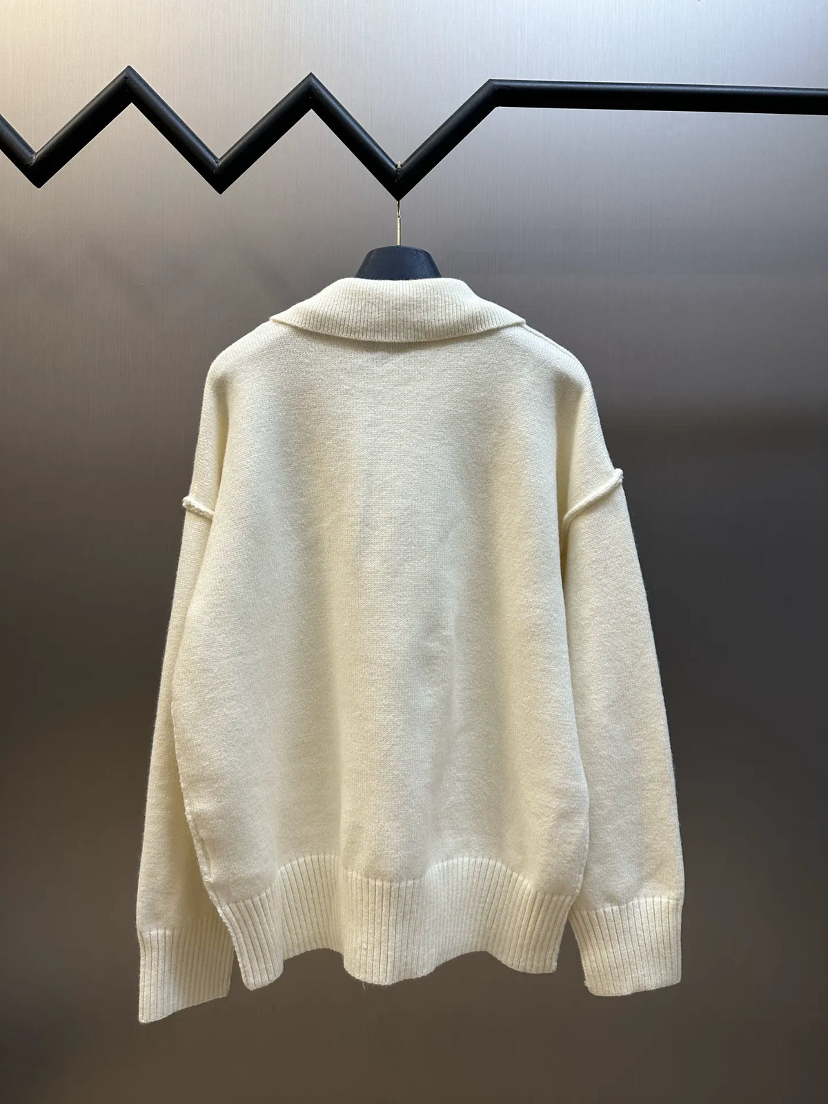 Off-white knit sweater back view with ribbed hem and relaxed shoulder line