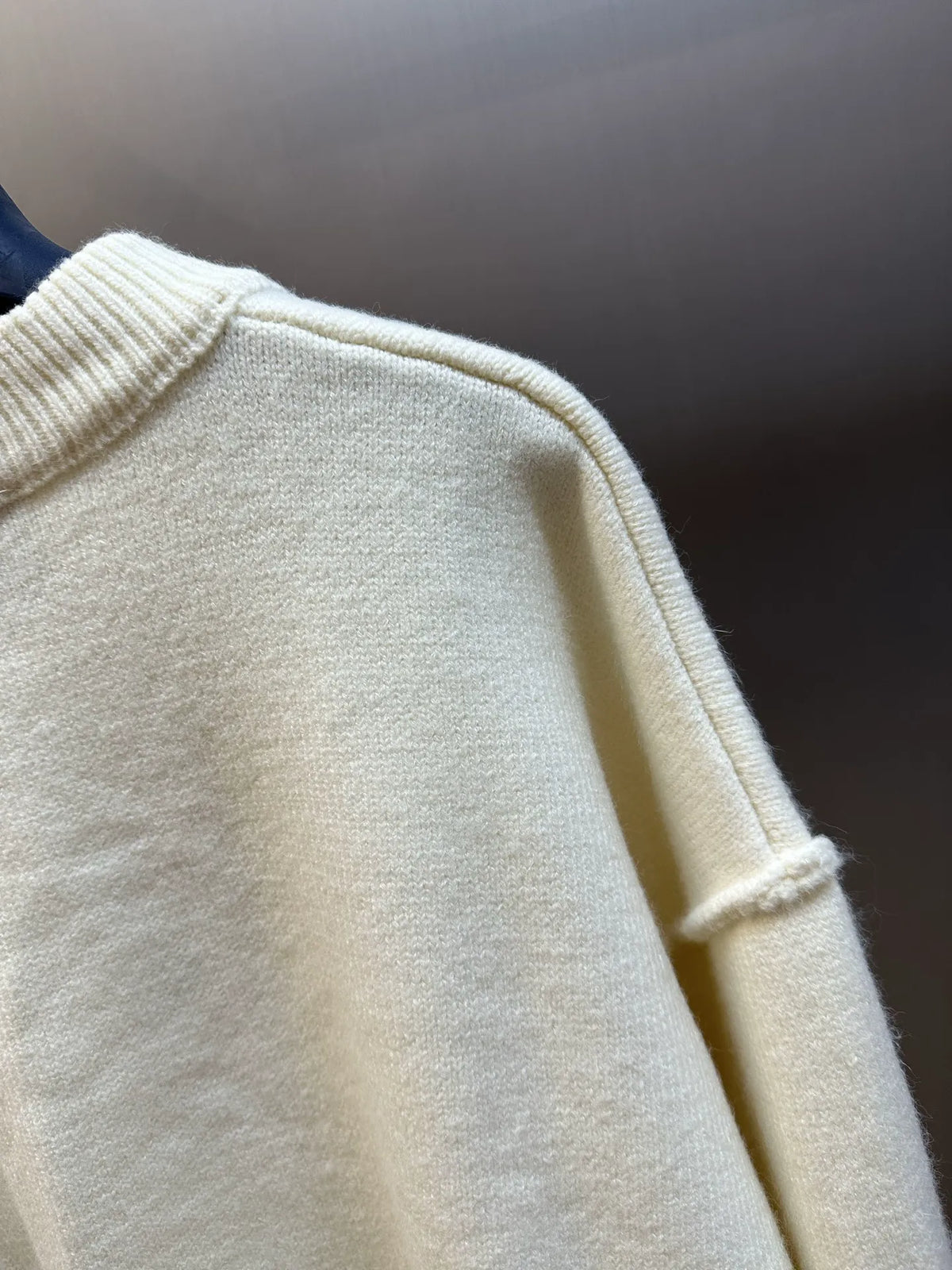 Amiri cream knit sweater close-up of ribbed collar and sleeve cuff