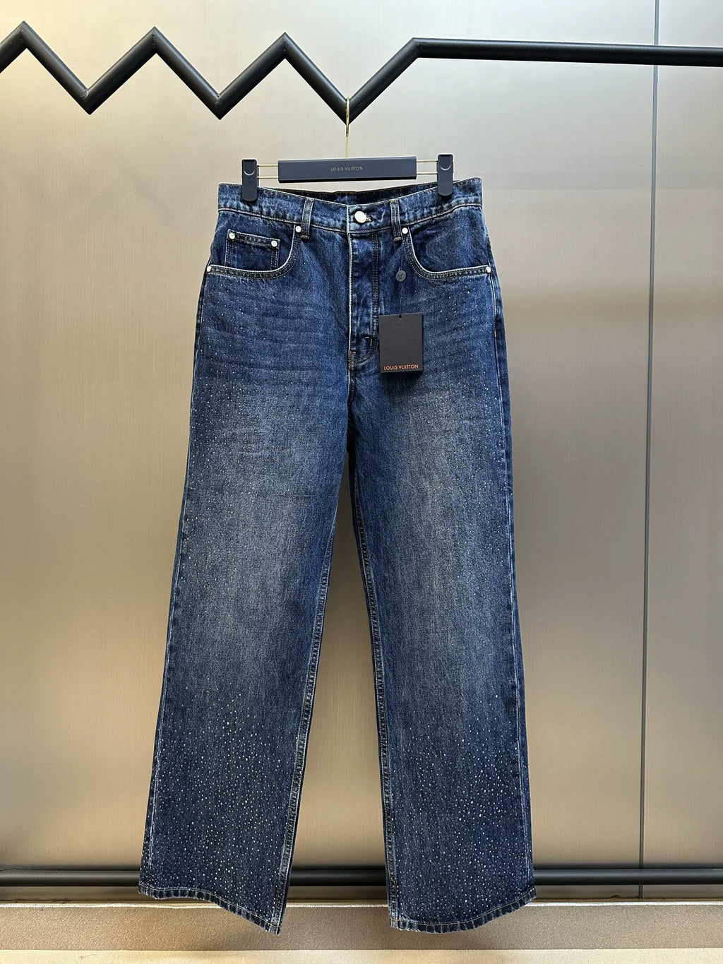 Dark blue denim jeans with button fly, belt loops, and straight wide legs.
