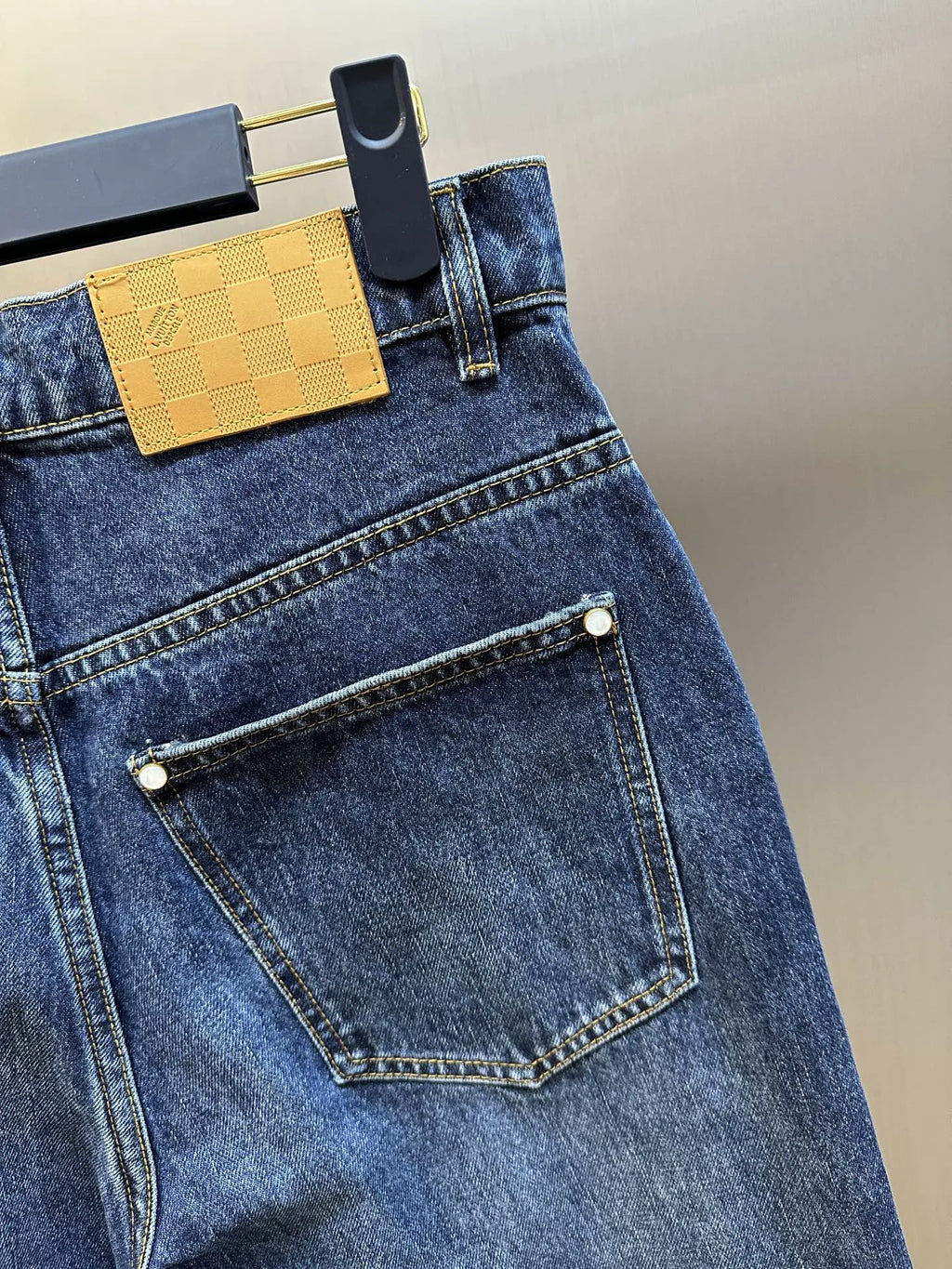 Dark blue denim jeans with front pocket and stitched edge trim.