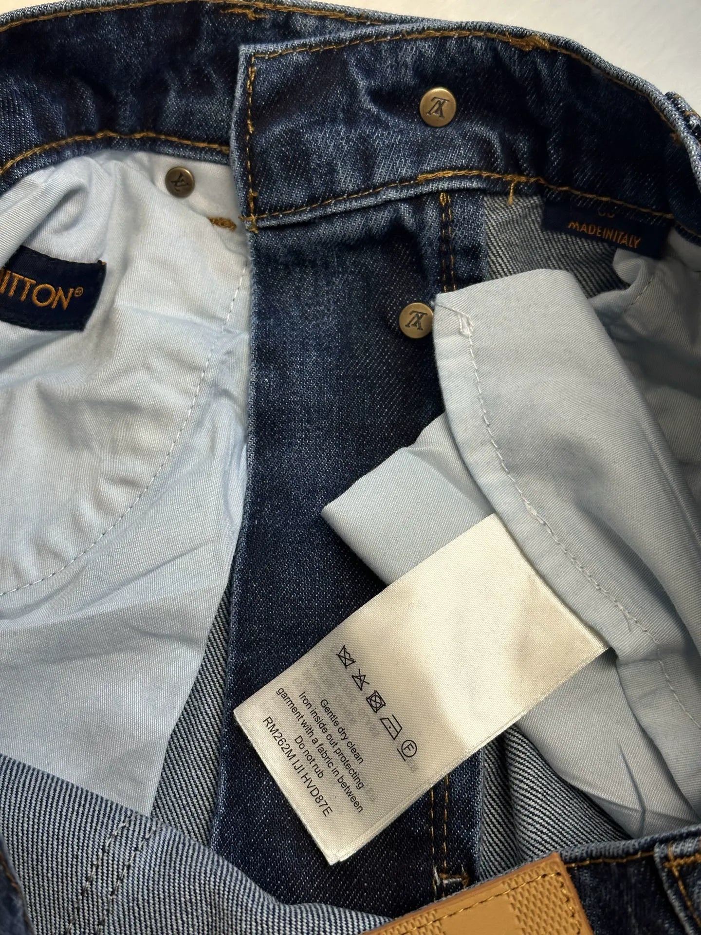 Dark blue denim jeans with inner lining and care labels at the waistband.