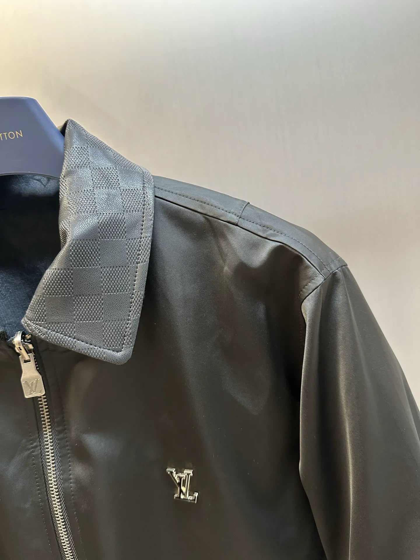 Dark monogram zip-up jacket side detail with small zipper pocket