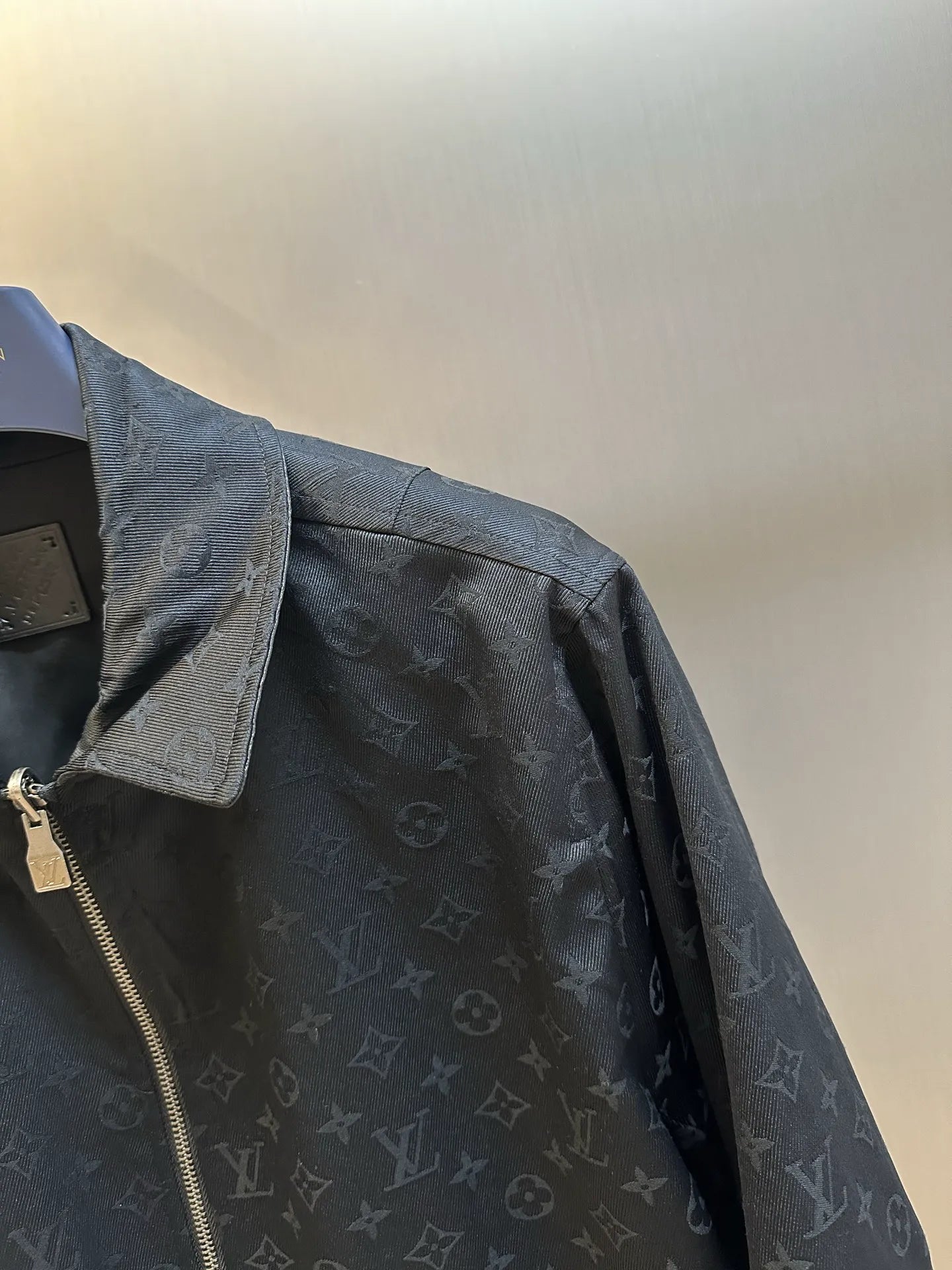 Dark monogram zip-up jacket shoulder detail with snap flap pocket