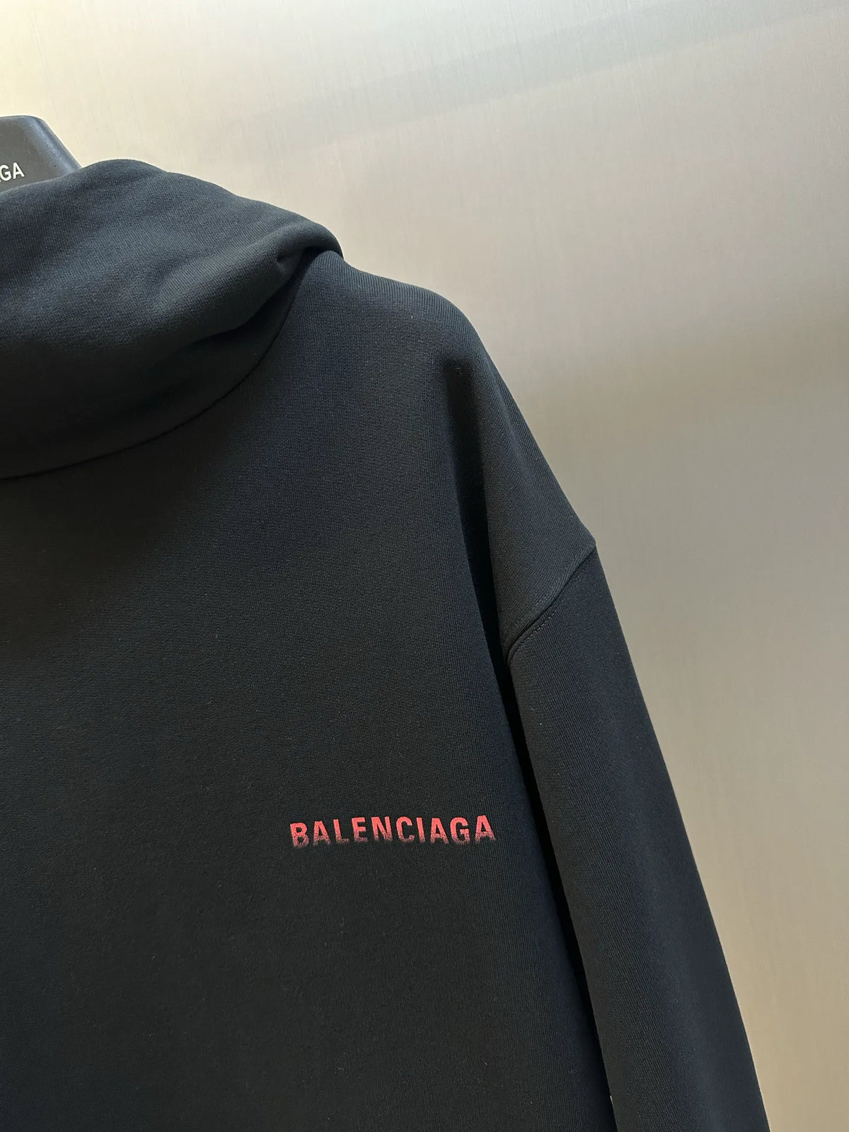 Black hoodie sleeve with red BALENCIAGA logo detail