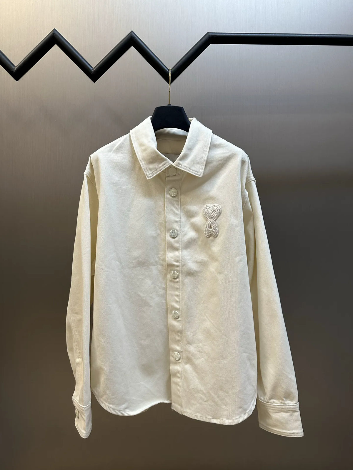 Cream long-sleeve button-up shirt with pointed collar and embroidered heart logo