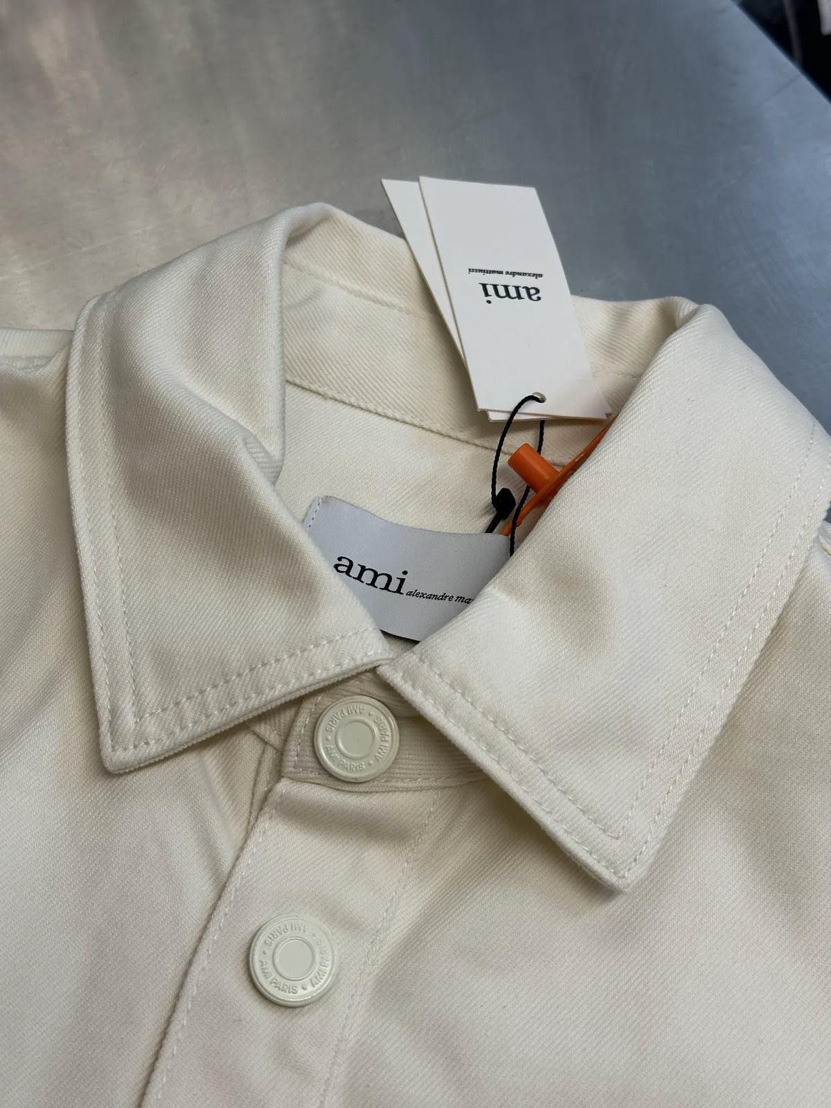 Cream button-up shirt collar close-up with round buttons and hanging tag