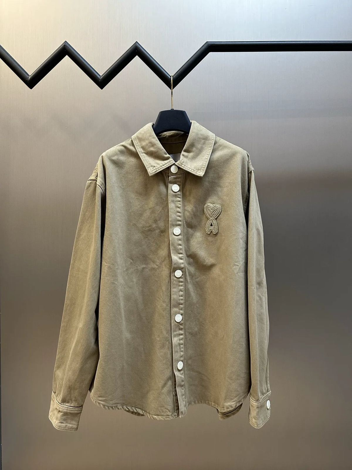 Light tan long-sleeve button-up jacket with pointed collar and chest buttons