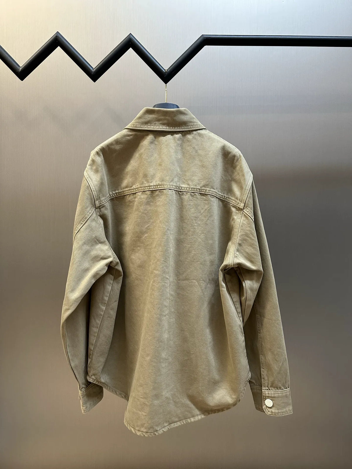 Light tan long-sleeve button-up jacket with stand collar and back yoke seam