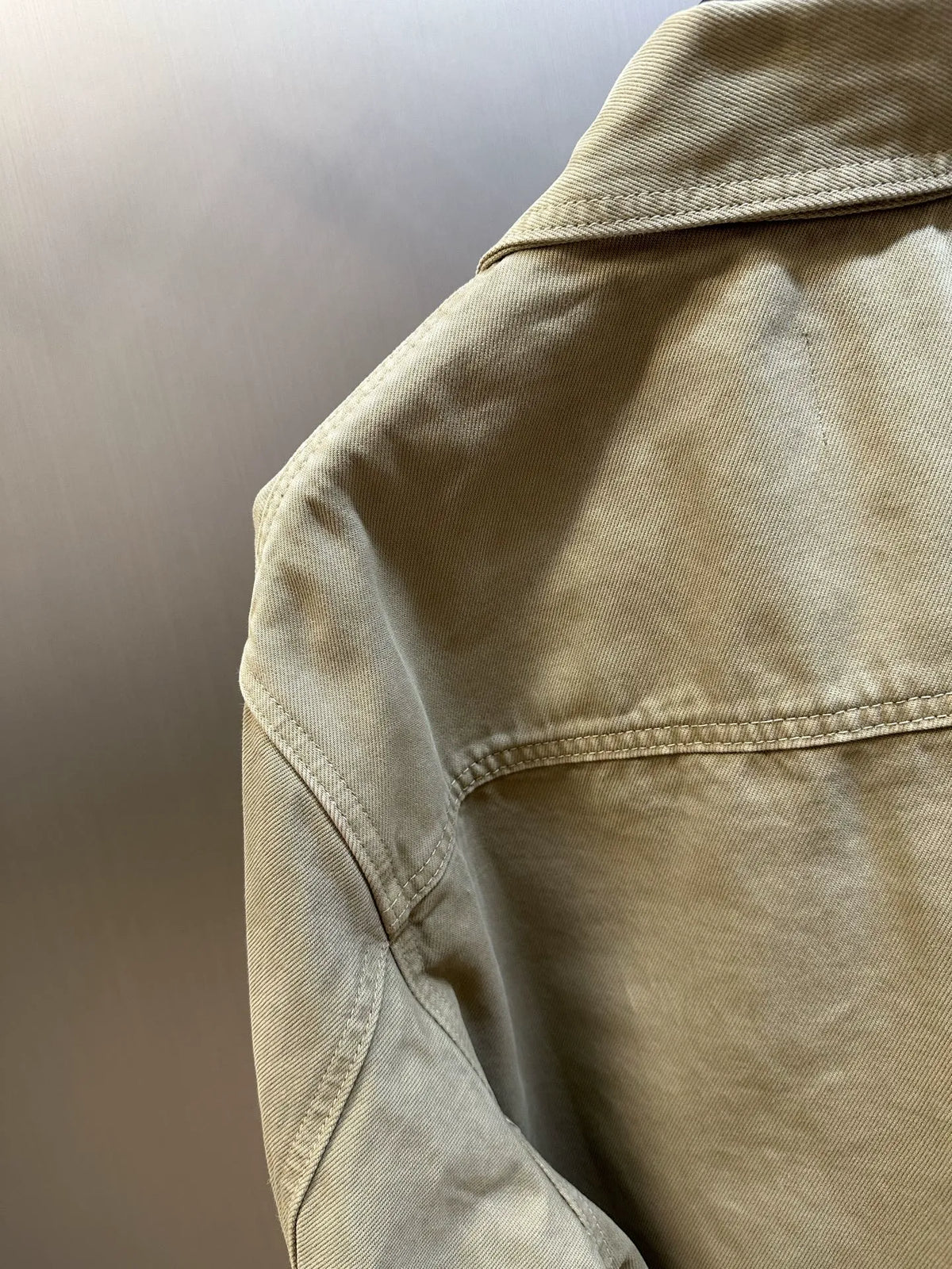 Light tan jacket sleeve with stitched seam and curved cuff hem