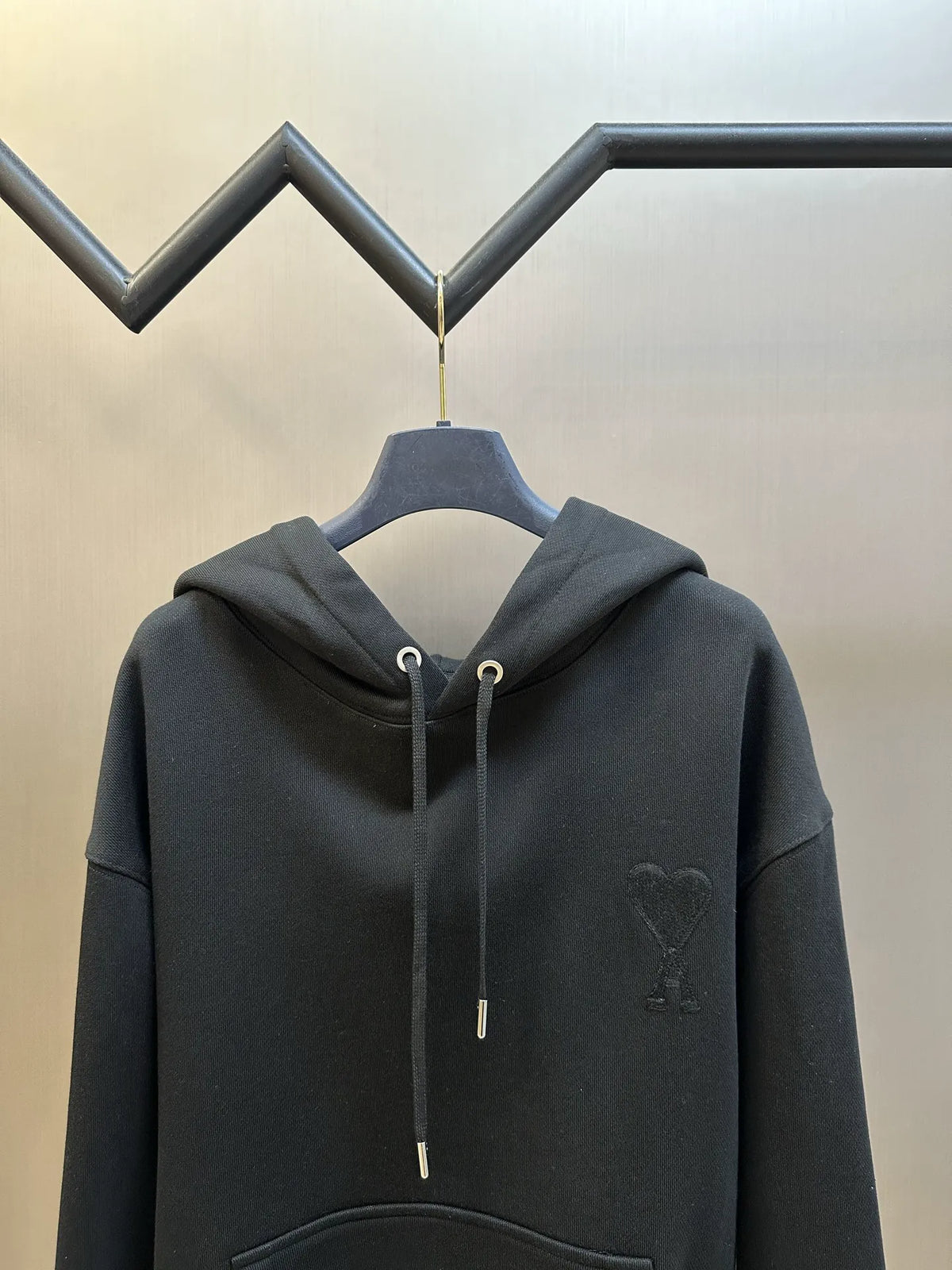 Black pullover hoodie with drawstring hood and kangaroo pocket, small chest logo