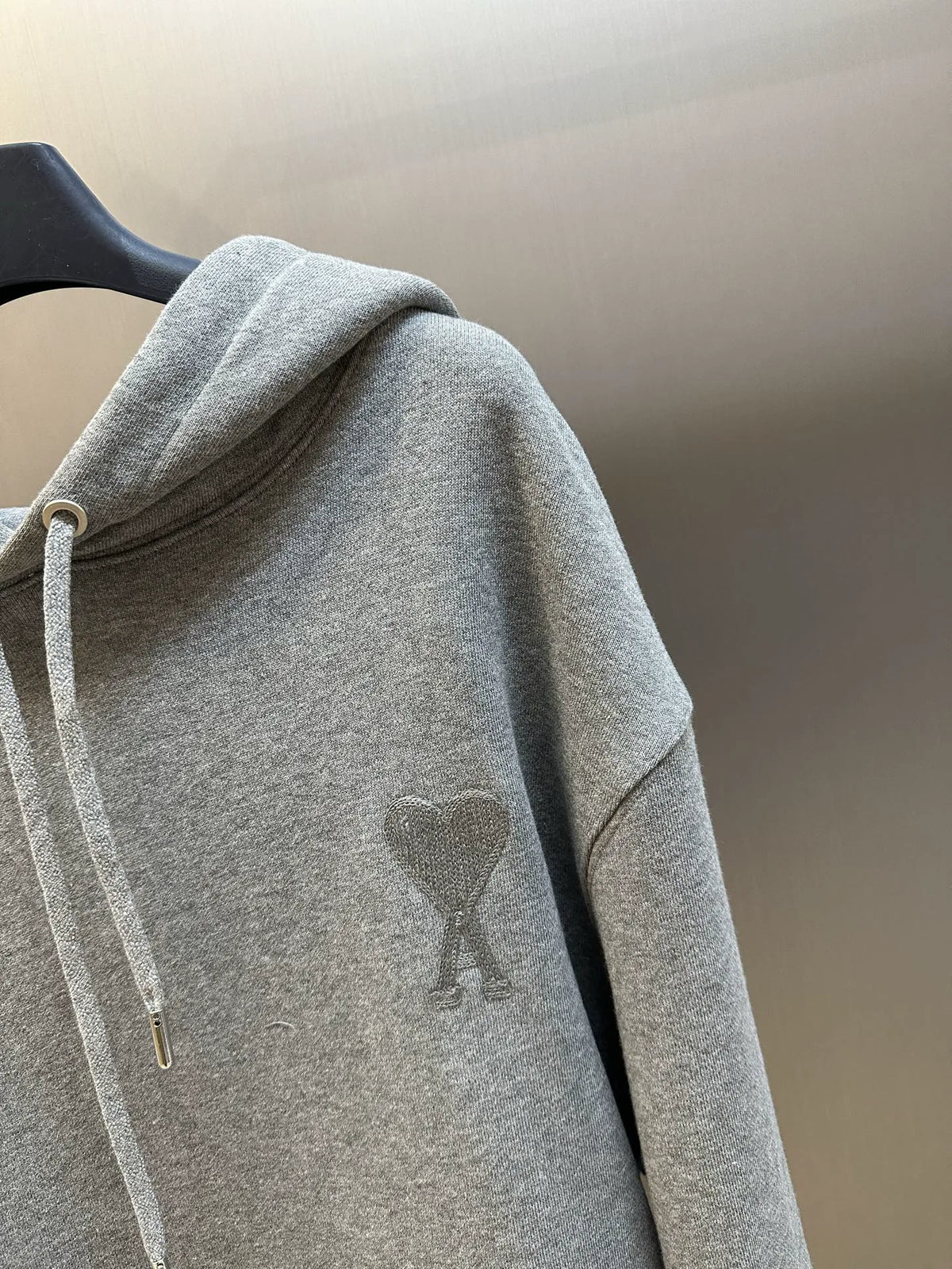 Gray hoodie close-up of chest logo and long sleeves with drawstring