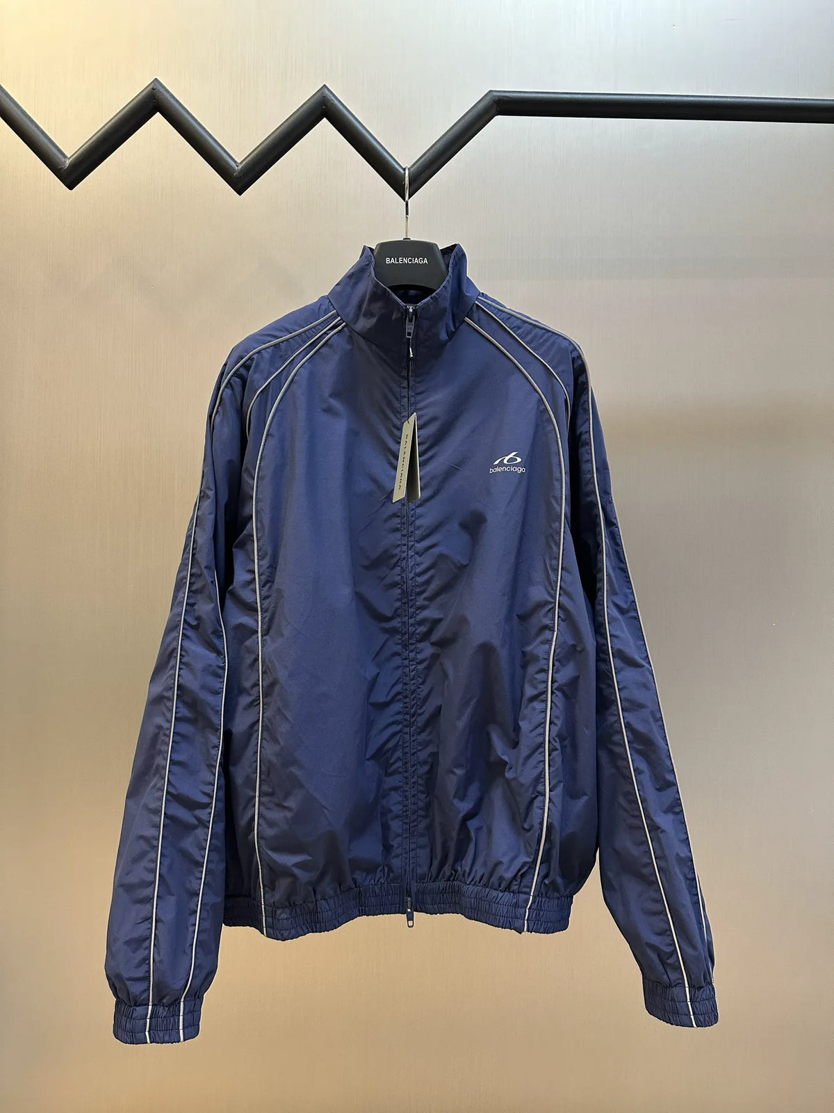 Navy zip-up jacket coat with Balenciaga logo, standing collar, and white track stripes