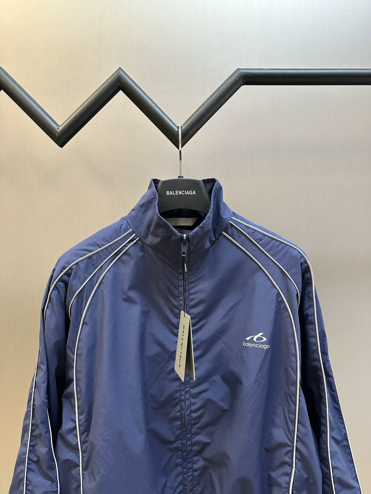 Navy zip-up jacket with Balenciaga chest logo and white stripe detailing along shoulders