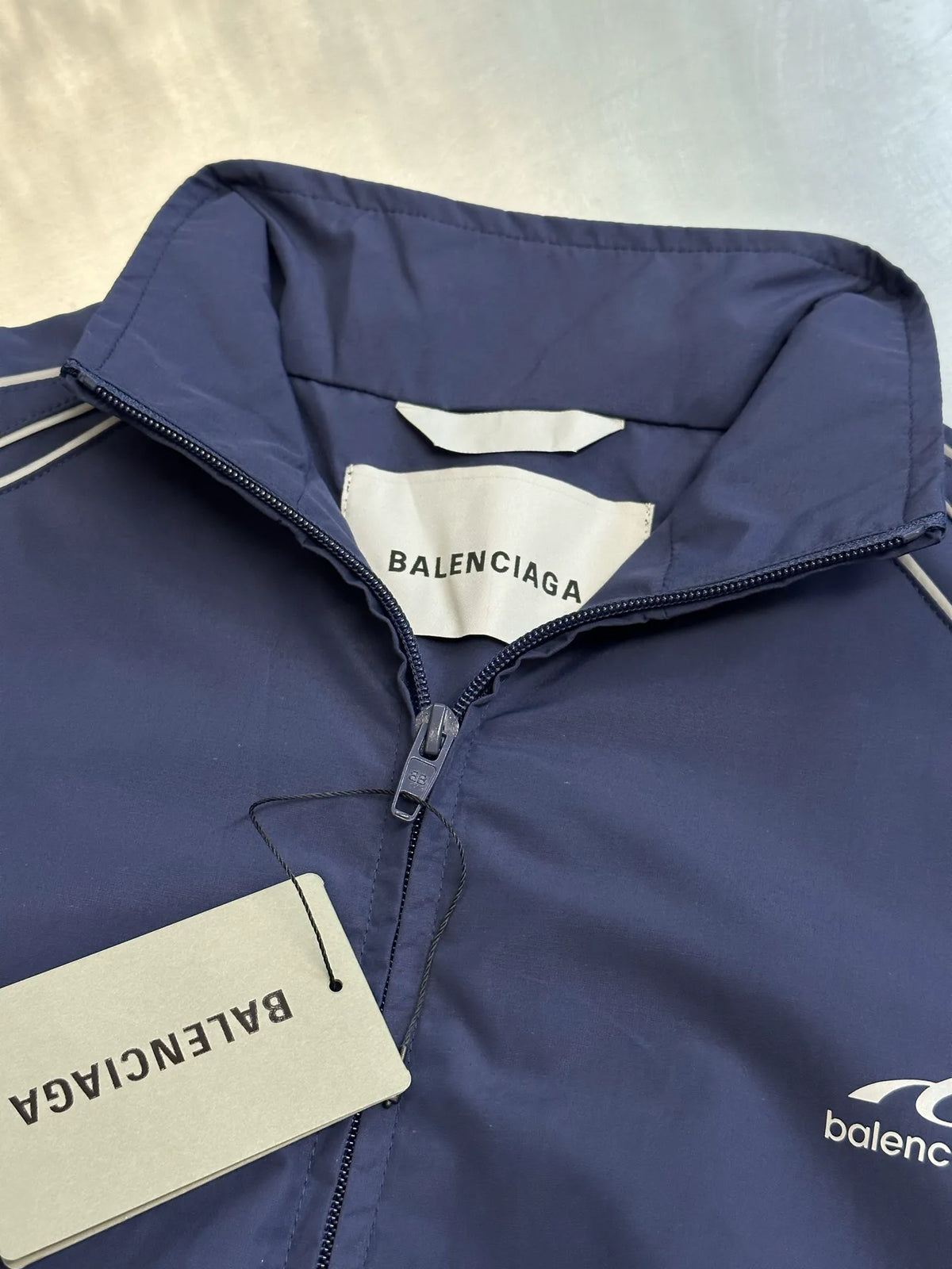 Navy high-collar zip jacket with Balenciaga label and white contrast trim