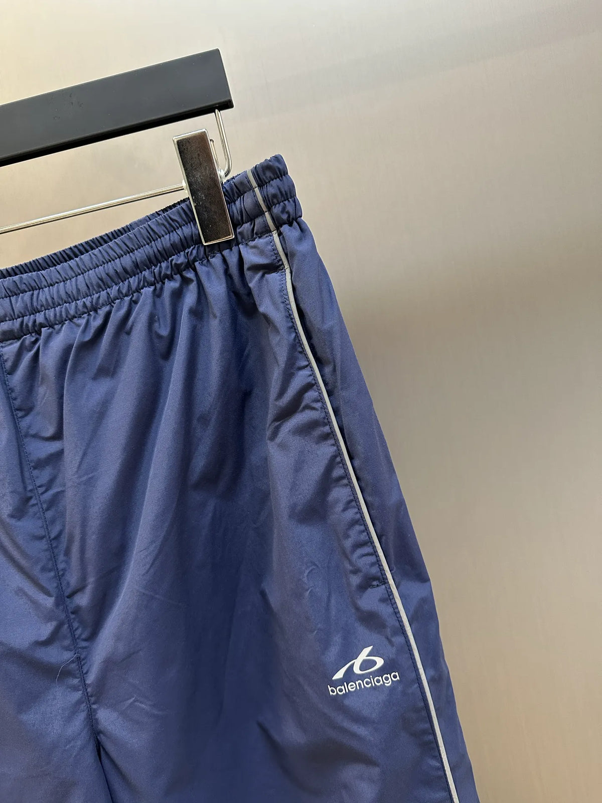 Navy Balenciaga pants close-up of elastic waistband and side piping stripe