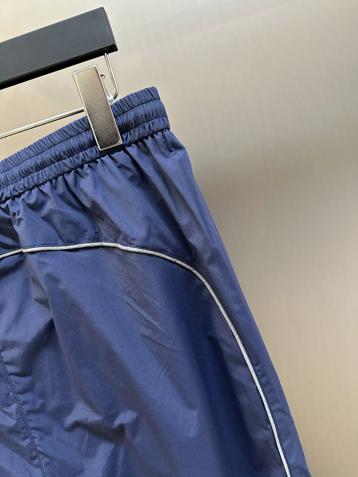 Navy Balenciaga pants close-up of elastic waistband and side stripe trim