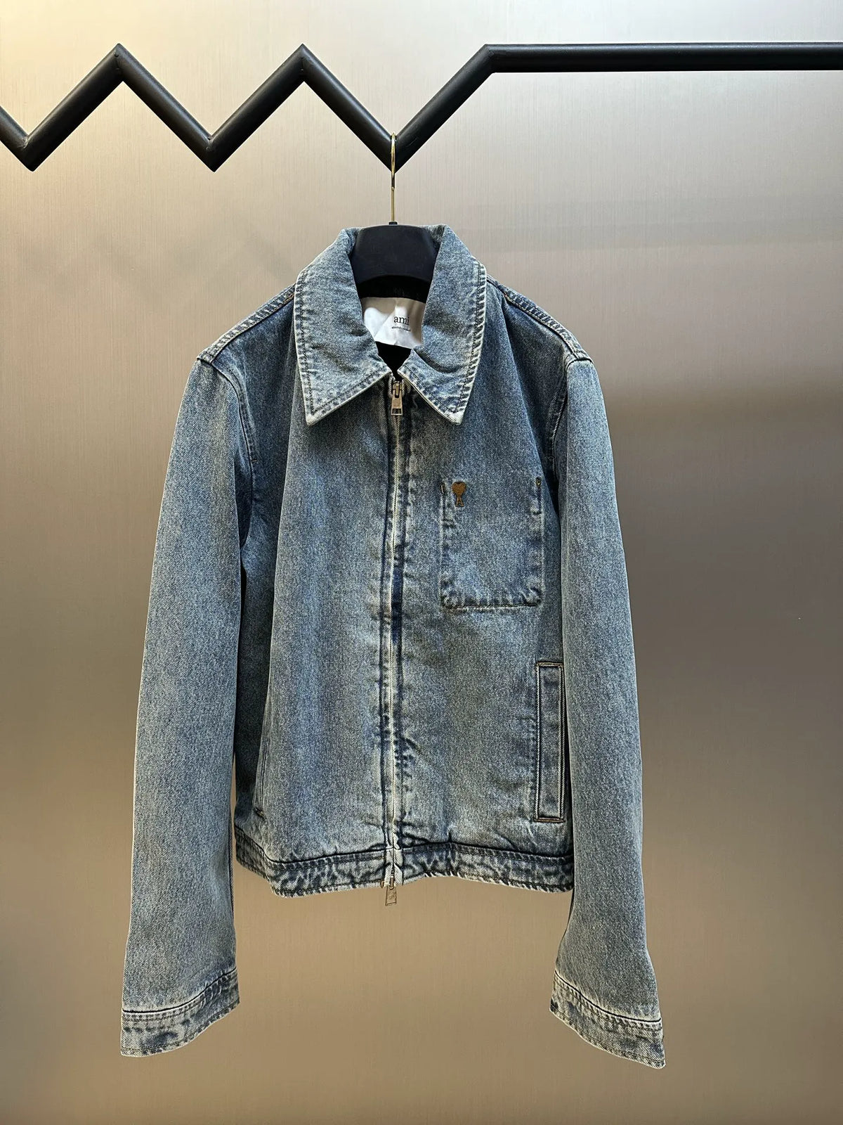 Light wash denim jacket with pointed collar, front button closure, and chest pockets