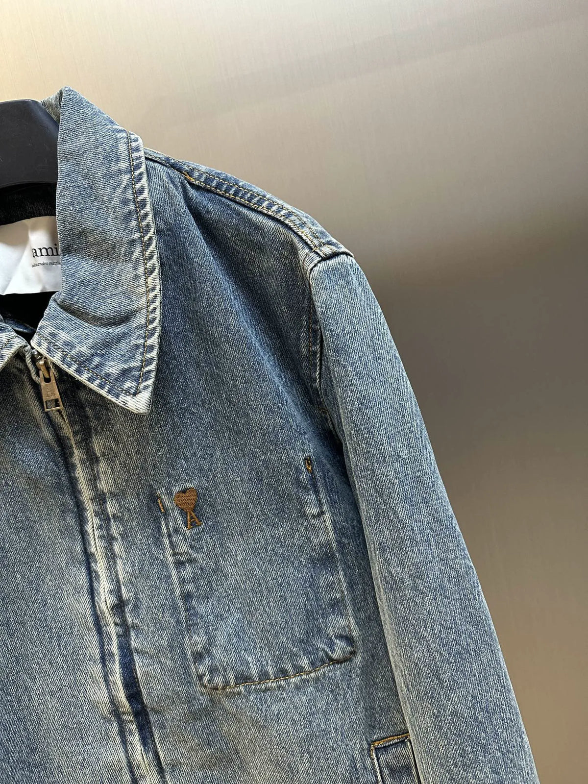 Light wash denim jacket close-up of chest pocket and embroidered detail