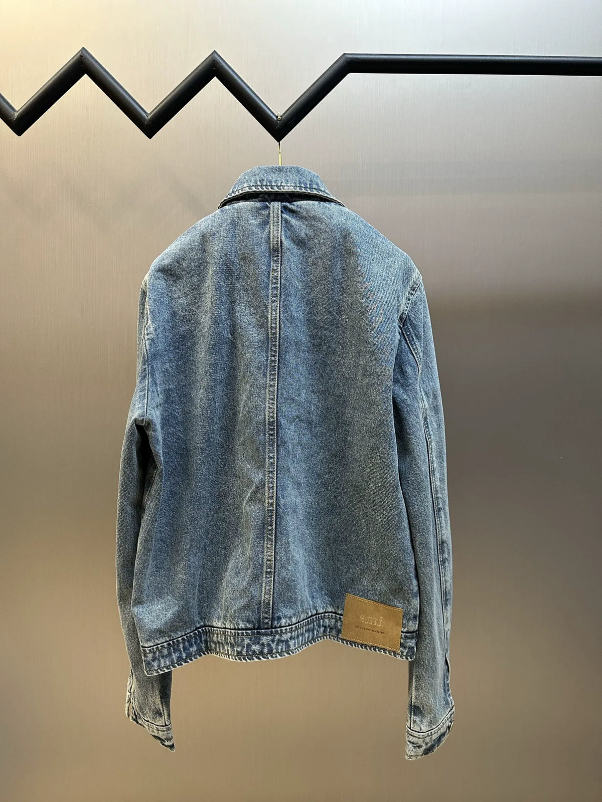 Light wash denim jacket back view with pointed collar and center button placket