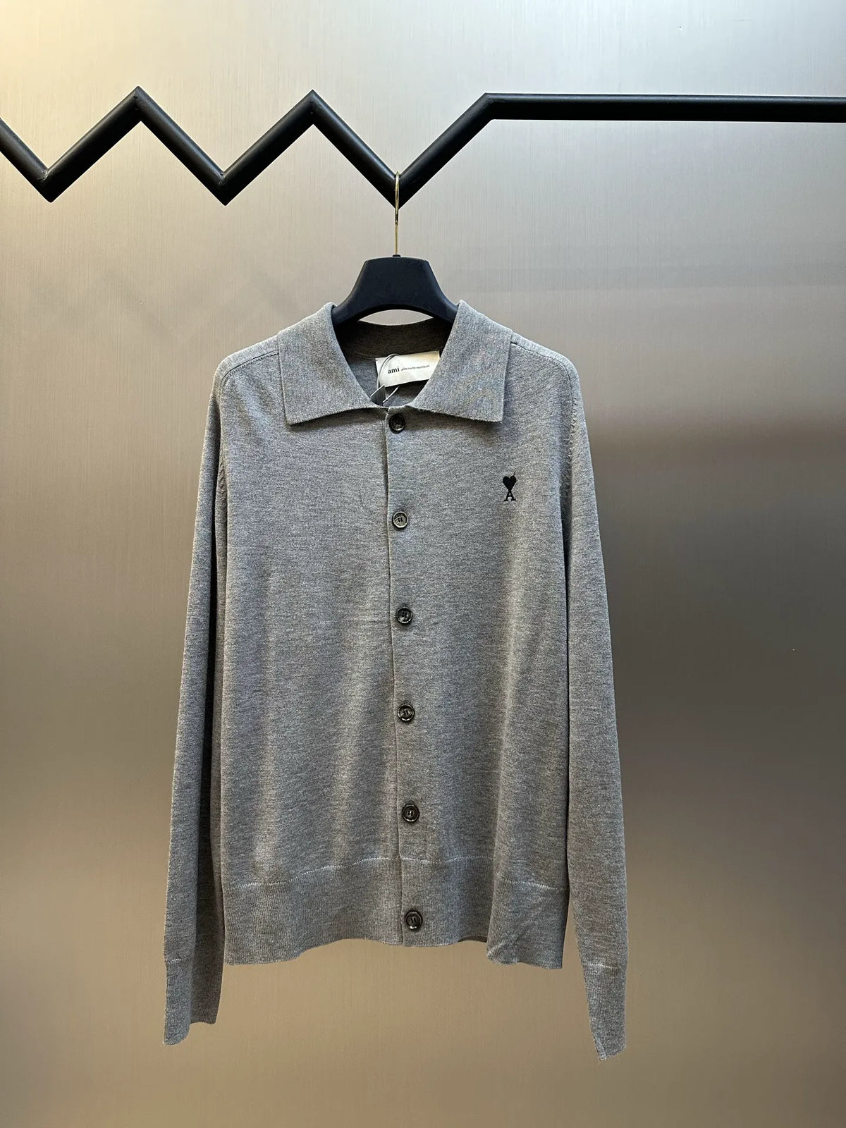 Gray knit long-sleeve polo shirt with button placket and small black logo