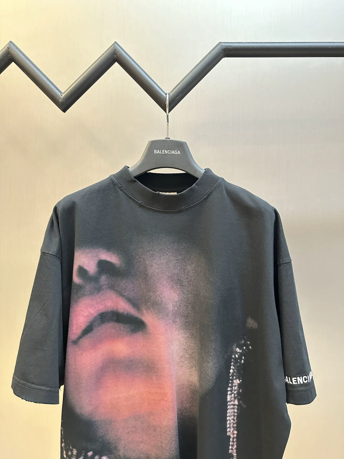 Black Balenciaga T-shirt on hanger with face graphic and rhinestone trim detail