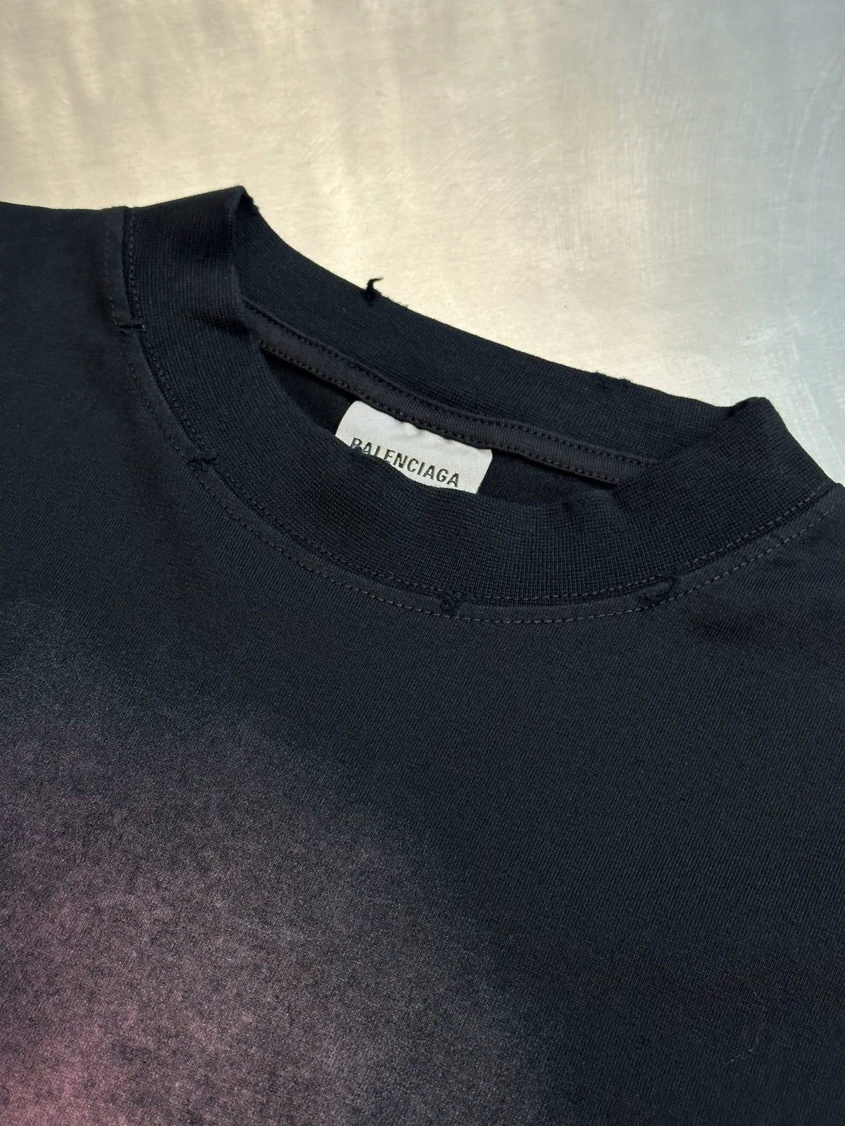 Black Balenciaga T-shirt neckline close-up with brand tag on inner collar